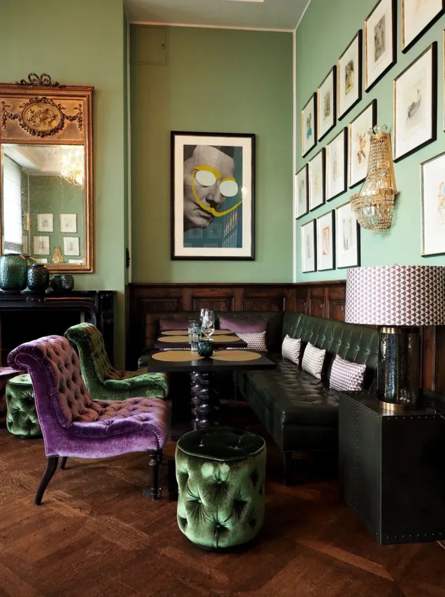 Interior Studio Isabella Hamann Contract Interior GRANDHOTEL SCHLOSS BENSBERG, Salvador Dalí fireplace bar, with deep green and purple tones, with two velveted dinning chairs.