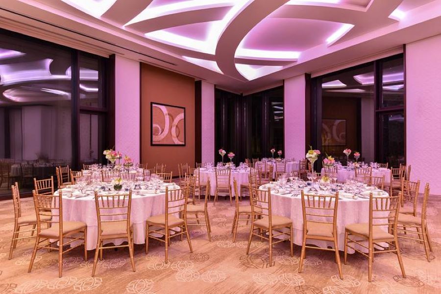 Restaurant hotel with white rond tables and gold chairs, design by Decorelle