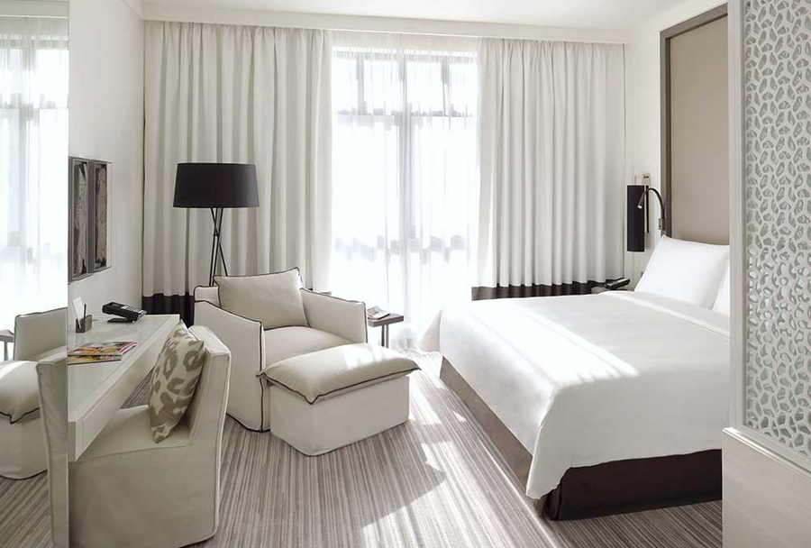 A hotel room with bespoke upholstery and custom bed.